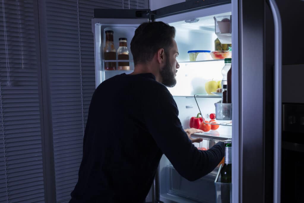 Man Looking At Food Kept In Refrigerator